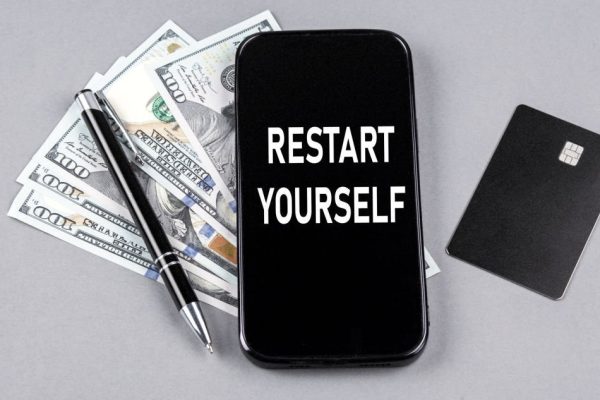 Credit card and text RESTART YOUR on smartphone with dollars and pen. Business concept